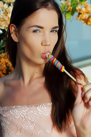 Sexy brunette Lovenia Lux sucks suggestively on her candy, her beautiful blue eyes so flirtatious